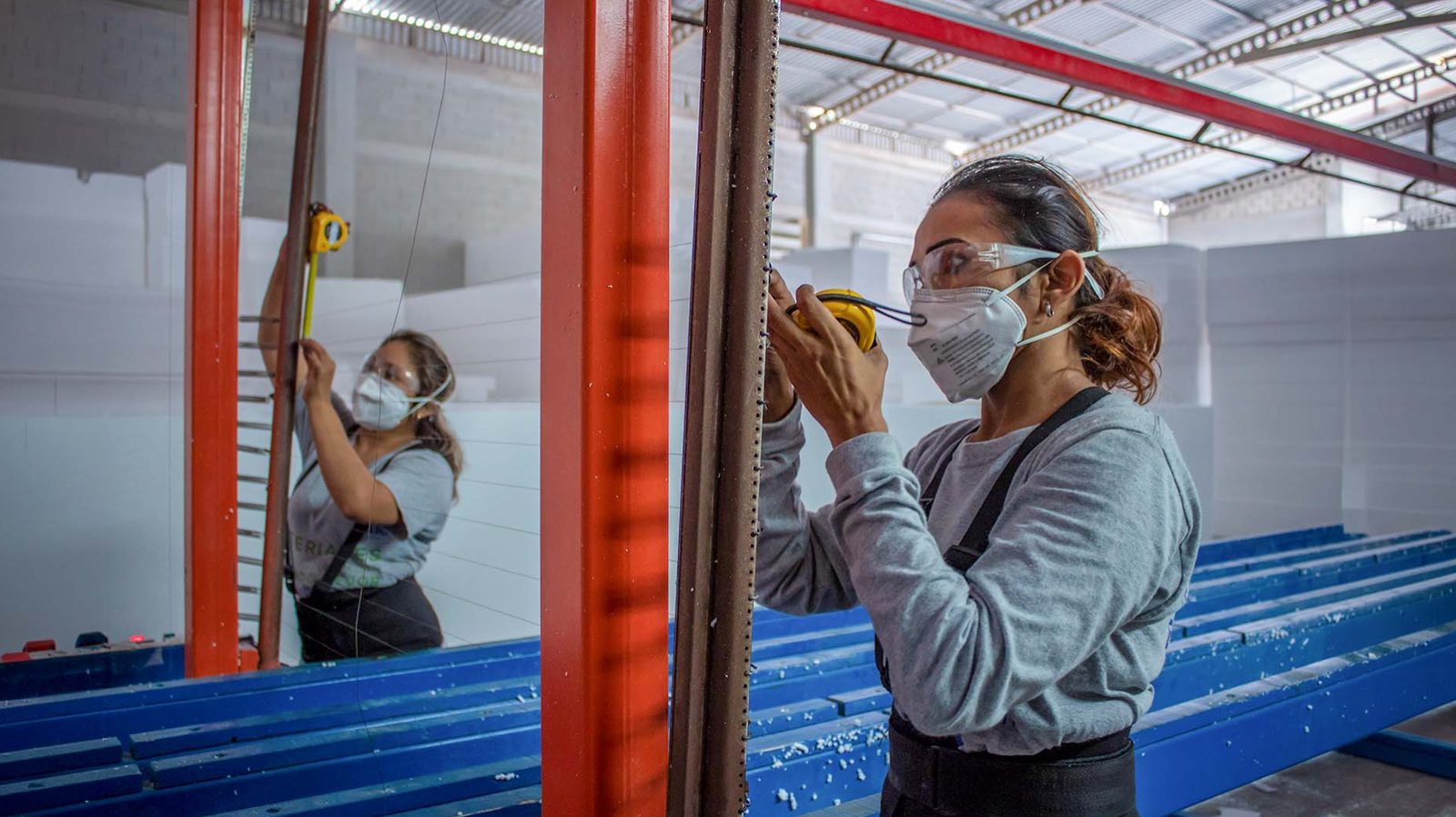 Colaboradora midiendo panel en planta